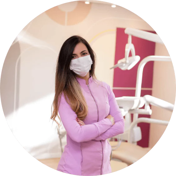 Doutora Luciana D'Angelo, sorrindo, de máscara, com os braços cruzados